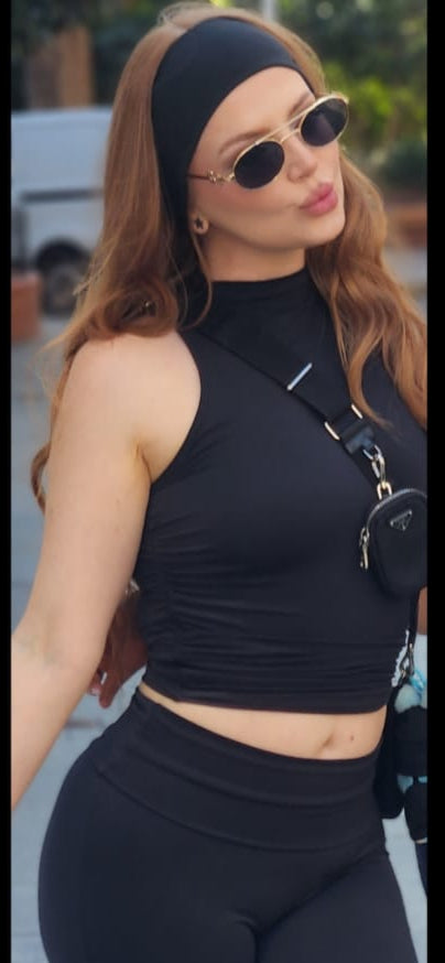 Woman in black outfit with sunglasses on a street background